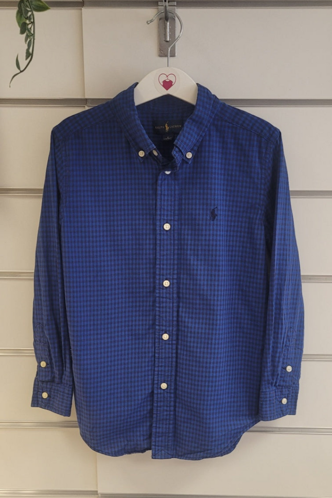 Blue checkered shirt hanging on a white wall