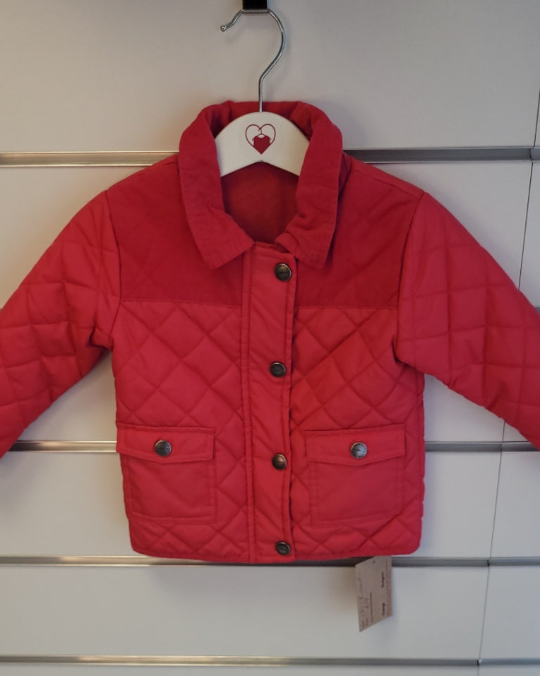 Red quilted jacket on a hanger against a white wall.